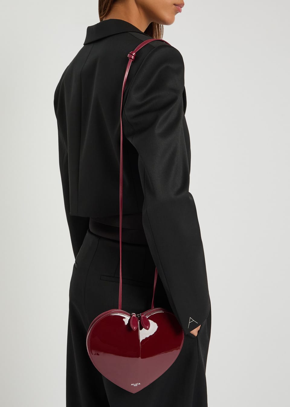 ALAÏA Le Coeur patent leather cross-body bag burgundy